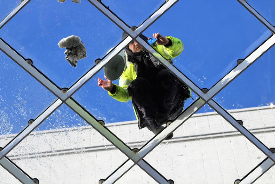 The shopfront window of a commercial retail space features large, frameless glass panels with a frosted appearance, providing privacy and a clean, modern look. The glass is free from smudges or dirt, 